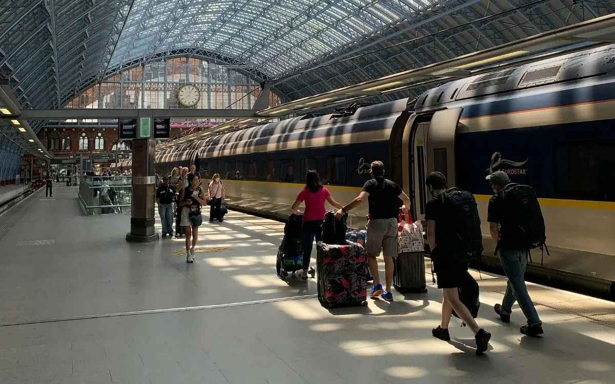 Reizigers met koffers langs een Eurostar op London St Pancras
