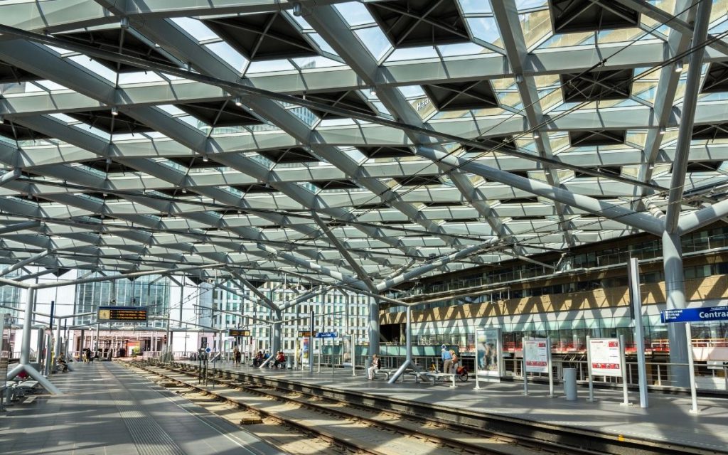Perronhal van Den Haag Centraal met de glazen overkapping en reisinformatieborden