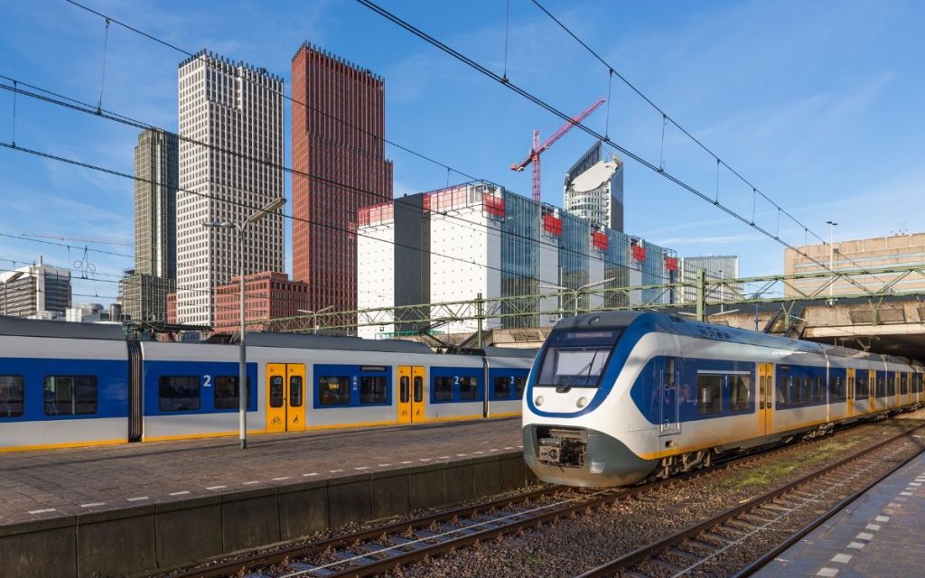 Perron van Den Haag Centraal met een NS-intercity en de skyline van Den Haag op de achtergrond