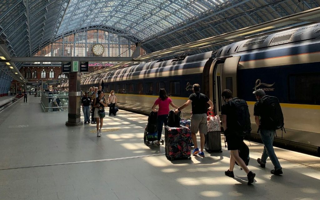 Reizigers met bagage lopen langs een Eurostar-trein op het perron van London St Pancras